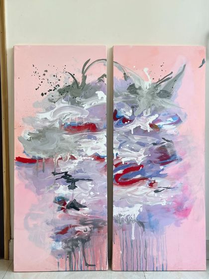 This is a diptych, a set of two paintings designed to be displayed together. The abstract design flows across both canvases, creating a larger, more impactful piece with beautiful drips and splashes of color.