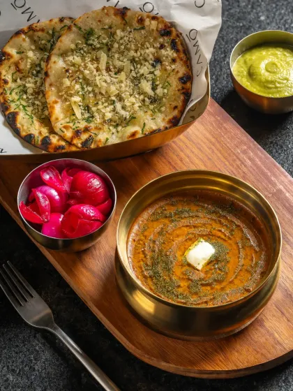 Dal Makhani with a dollop of butter, served with garlic naan and pickled onions for Camo Noida. A classic North Indian comfort meal.
