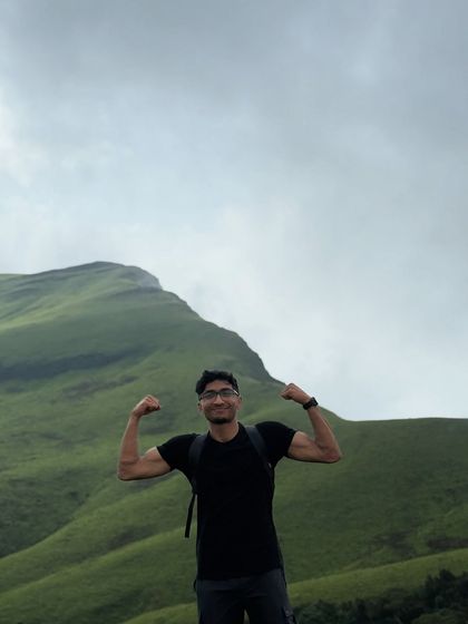 A trekker showing off his strength with the beautiful Netravathi hills in the background.