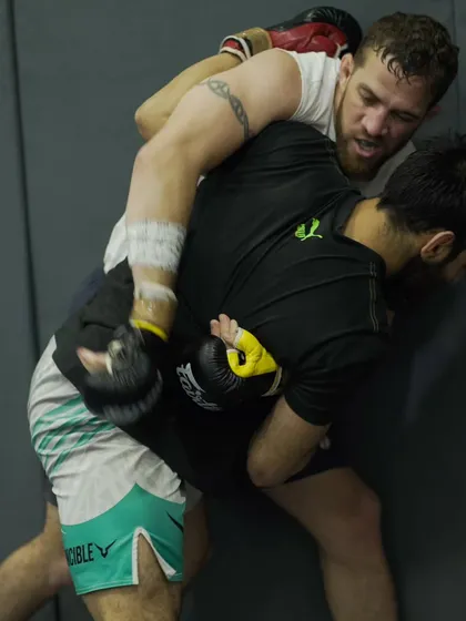 Two members of our competition team wrestle for position against the cage. This is a critical skill in MMA, and our pro fighters drill it constantly.