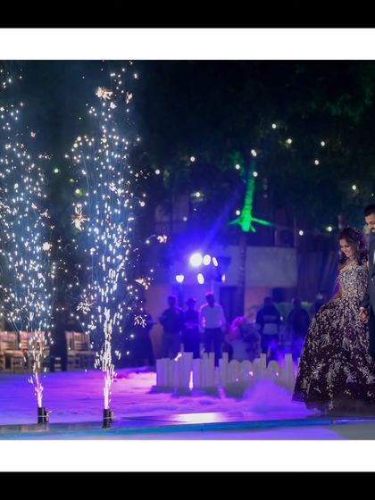 A grand reception entrance. The couple makes their way onto the dance floor surrounded by cold pyro sparklers, creating a dramatic and magical start to their celebration.