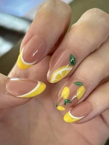 A fun and fruity summer design. This look features a negative space background with cheerful yellow French tips and hand-painted lemon art, perfect for a vacation.