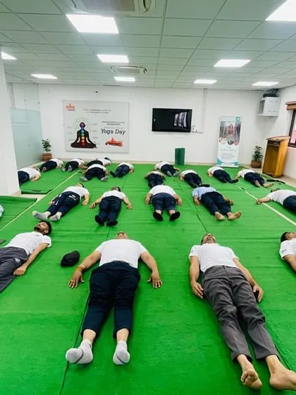 A moment of deep rest and integration. Participants lie in Savasana (Corpse Pose) at our Hoshiarpur studio during an International Day of Yoga event, absorbing the benefits of their practice.