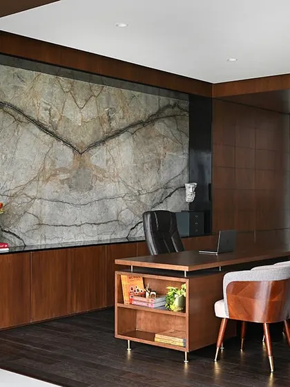 For this Chairman's office, we aimed for quiet luxury. The centerpiece is a book-matched marble slab that acts as a piece of art, complemented by rich wood paneling and a bespoke desk, creating a space that is both powerful and serene.