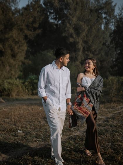 A candid shot of a couple walking and talking in a rustic, wooded area. The natural interaction and soft light create an authentic and heartfelt portrait.