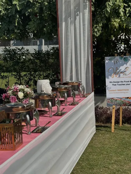 A classic white and pink buffet line at a garden wedding, with our service banner prominently displayed.