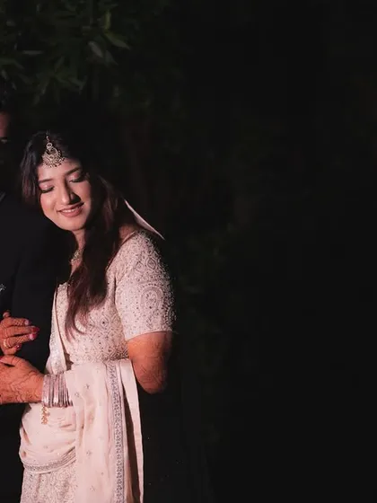 A romantic portrait of a couple under the night sky. The dark, moody lighting creates an intimate atmosphere, focusing all the attention on their connection.