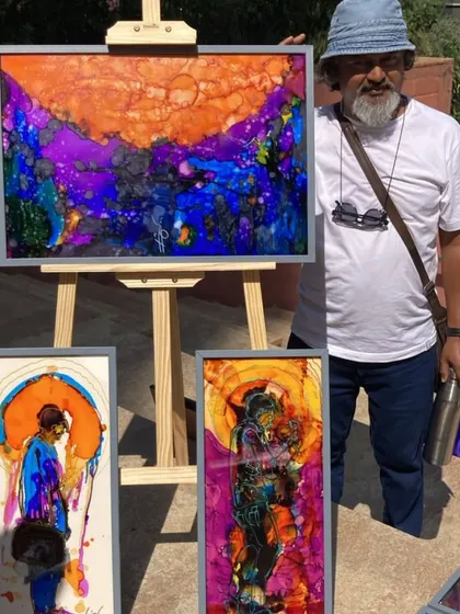 An artist displays his collection of stunningly colorful abstract ink paintings at our Sublime Fiesta, engaging directly with the public.