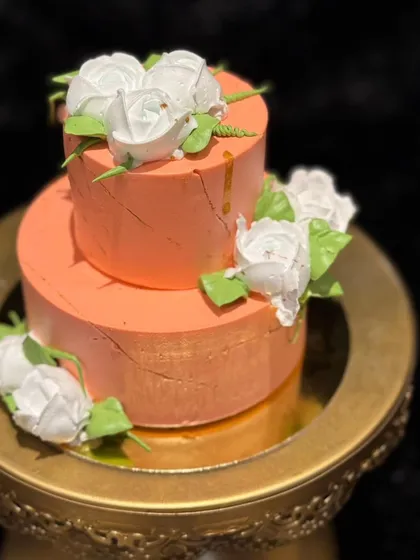 This peach-colored mini two-tier cake is decorated with delicate white buttercream roses. It’s an elegant and understated choice for celebrating the New Year.