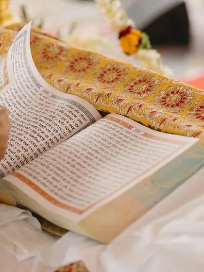 A close-up of the Guru Granth Sahib, the holy scripture at the center of the Anand Karaj ceremony. This image captures the reverence and spiritual heart of a Sikh wedding.