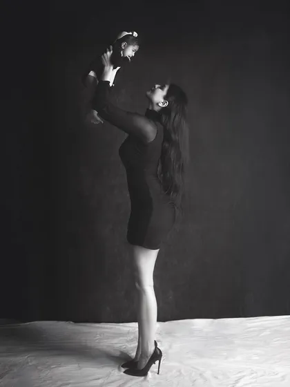 A powerful and elegant portrait of a mother holding her baby. The dramatic lighting and black and white edit create a stunning, high fashion look.