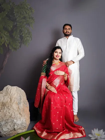 Celebrating our beautiful traditions with a classic Seemantham-style maternity portrait. The rich red saree and traditional attire for the couple make for a truly timeless and elegant memory.