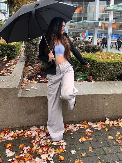 An autumn look from a rainy day. This outfit with a light blue crop top and grey wide-leg pants is perfect for a cool, transitional weather day.