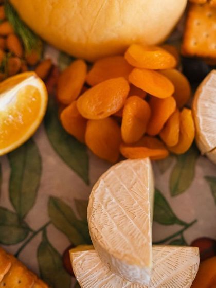 A close-up of a cheese board with dried apricots, nuts, and crackers, a sophisticated and delicious offering from our Mother's Day brunch.