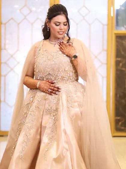 The full view of her stunning engagement gown. The high ponytail and flawless makeup create a chic and modern look.