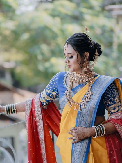 The bride looking elegant and poised in her traditional Nauvari saree.