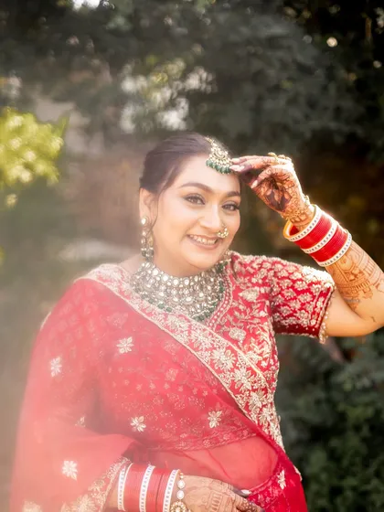 The quintessential happy bride in classic red. This candid shot captures the pure joy and confidence that my work inspires, highlighting a timeless look with defined eyes and a radiant smile.