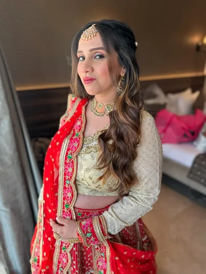 A confident pose from the bride. Her makeup is kept minimal to let her vibrant red and cream lehenga do the talking.