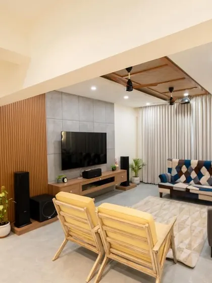 A modern living room renovation featuring a mix of neutral tones and pops of color, with unique furniture pieces like a patchwork sofa.
