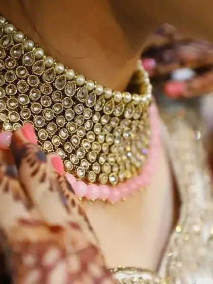 This is another angle of the bridal choker, capturing the craftsmanship and the way it complements the bride's attire and henna. These shots add an emotional connection to the product.