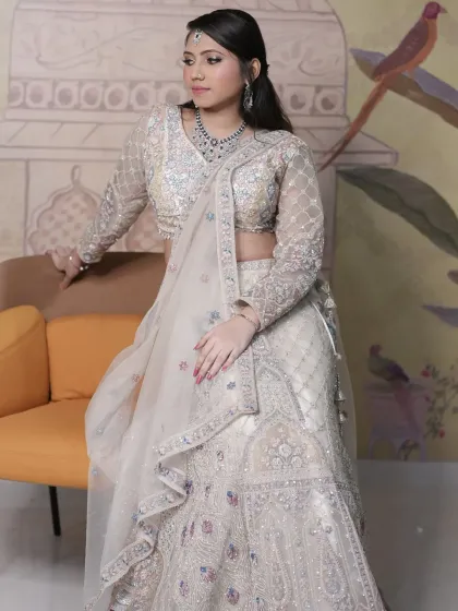 A full-length view of the pastel lehenga, showing the intricate work on the skirt and the elegant full-sleeve blouse.