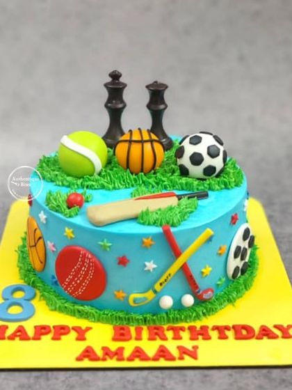 A multi-sport theme cake for an all-around athlete. This cake is covered in edible sports equipment, including a cricket bat, soccer ball, basketball, tennis ball, and chess pieces.