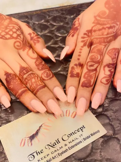 A simple and elegant choice for a bride. These coffin-shaped nails are painted in a soft, shimmery peach color that beautifully complements the detailed henna design.
