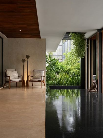 The veranda at Villa Shakthi serves as a traditional space for engagement, fronted by a large garden. We used granite and limestone for the surfaces, materials that extend from the exterior plinth to create a seamless transition from the built form to the open landscape.