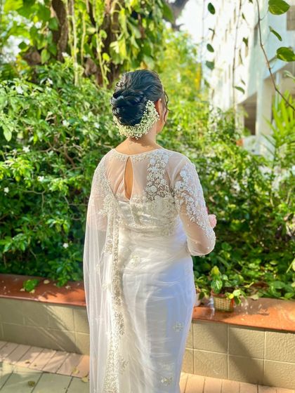 For this Christian bride, I created a classic, elegant low bun adorned with baby's breath. The style is timeless and sophisticated, perfectly complementing her beautiful white saree and veil.