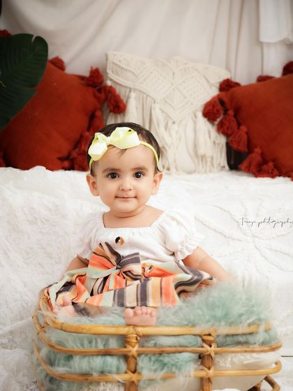 A sweet and simple portrait of a baby girl in a wicker basket. Her direct gaze and calm expression make for a beautiful milestone photo.