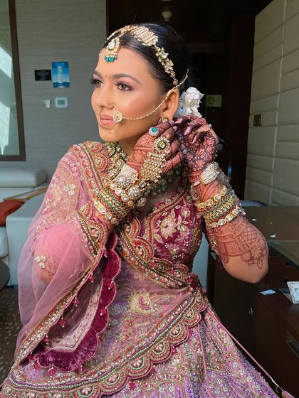 A candid shot of the bride getting her earrings on, showing how the floral bun looks from the side.