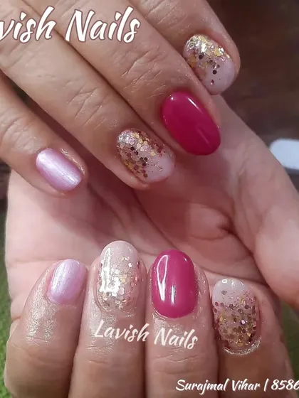A lovely manicure on shorter nails, combining magenta, a shimmery pearl-pink, and a chunky gold glitter accent.