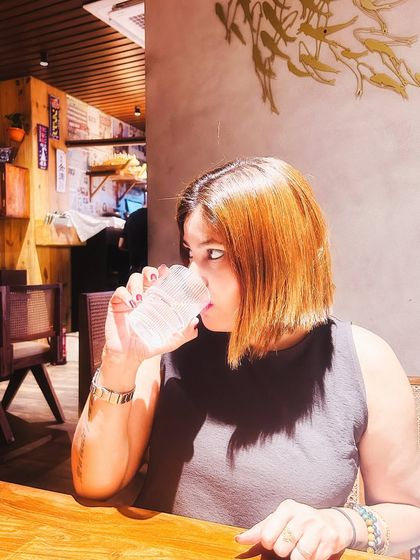 A candid photo of me at a restaurant, with beautiful lighting creating a warm and aesthetic mood.