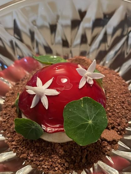 Another angle of the exquisite goose liver bonbon, showing the delicate flower garnish.