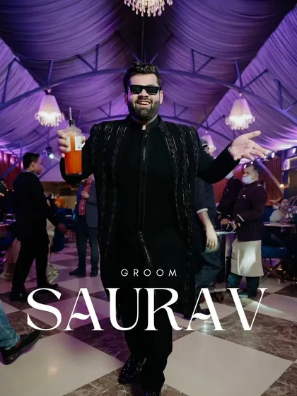 The groom, Saurav, looking confident and happy at his cocktail party. He is wearing a custom black bandhgala with tonal embellishments.