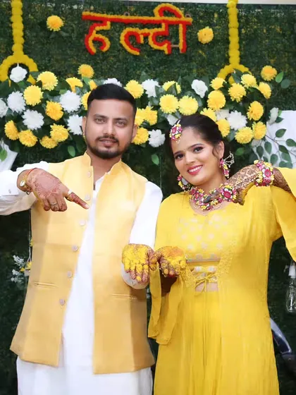 A fun pose from the couple, showing off their haldi-covered hands.