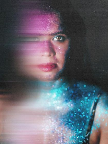 An experimental portrait combining glitter with a horizontal motion blur. The effect is futuristic and abstract, creating a unique piece of art.