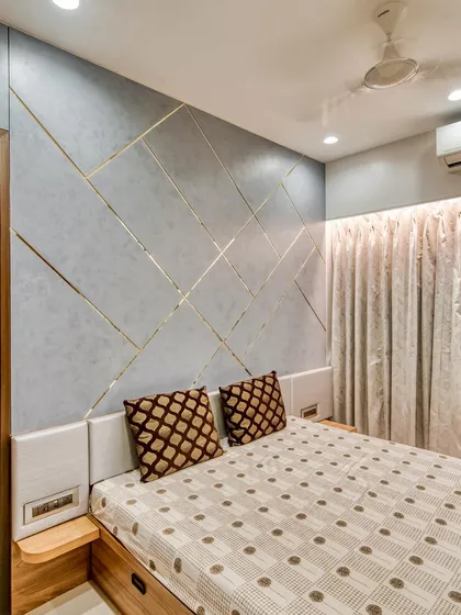 A stylish accent wall with geometric gold inlay serves as a headboard in this modern bedroom. It's a simple way to add a touch of luxury and personality.