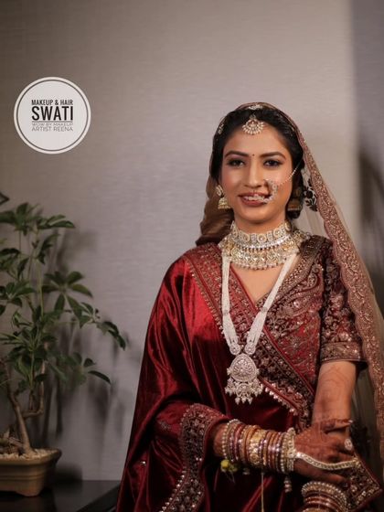A full view of Priya's stunning bridal outfit. The rich velvet and intricate embroidery are perfectly complemented by her elegant makeup and hair.