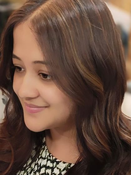 The light catches the subtle highlights in her new hair colour, demonstrating the dimension and texture achieved through the service.