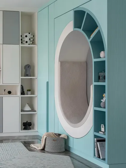 For this child's bedroom, we designed a world of imagination. The centerpiece is this cozy, circular reading nook built into the wall, surrounded by integrated shelving for books and treasures. It’s a functional and playful sanctuary for a child to read, dream, and grow.