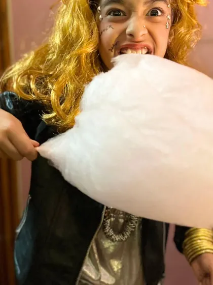 A ghostly rockstar takes a huge bite of pink cotton candy. Halloween is all about having fun and being silly!