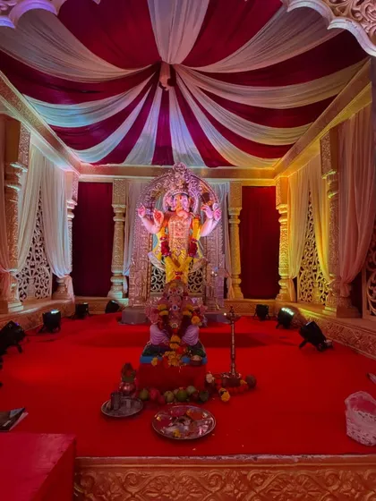 A classic Ganesh Chaturthi mandap I designed. The setup includes rich red and white drapes, intricate side panels, a raised platform for the idol, and professional lighting to create a divine atmosphere for Bappa.