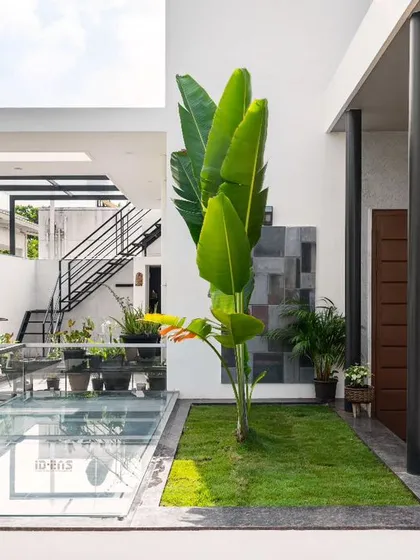 This courtyard in the Prakash Reddy Residence is a perfect example of our indoor-outdoor integration. The glass skylight over the water feature allows light to penetrate deep into the lower levels, while the open-air seating area acts as a private, green lung for the home.