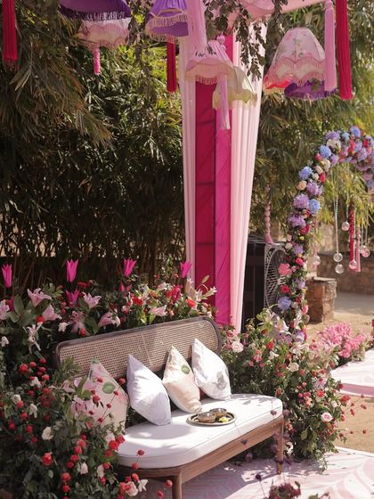 A side view of the Mehendi seating, showing how the floral arrangements and hanging decor elements come together to create a lush and immersive environment.