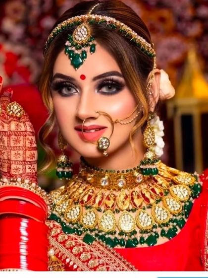This heavy Polki bridal set with green and red accents is a statement piece. It includes a choker, matha patti, and nath, all available for purchase.