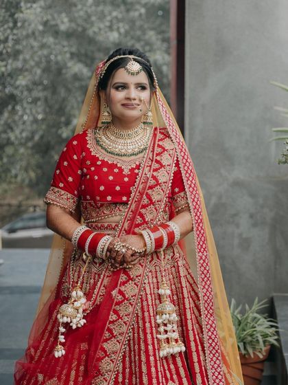 A full-length portrait of Payal, her pose confident and her red lehenga looking magnificent.