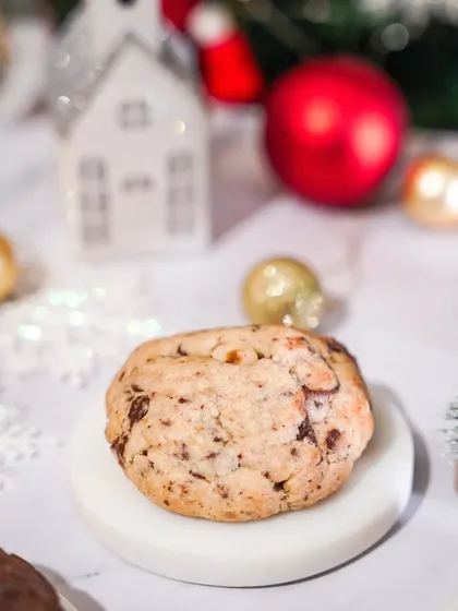 A classic chocolate chip cookie, styled simply in a bright and airy Christmas setting. This shot is clean, appealing, and focuses on the timeless appeal of the cookie.