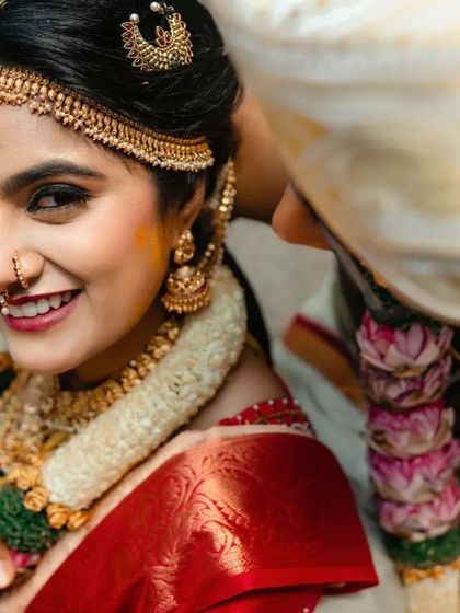 A beautiful close up of a bride, with the groom just visible beside her. This shot highlights her joyful expression and the intricate details of her wedding attire.