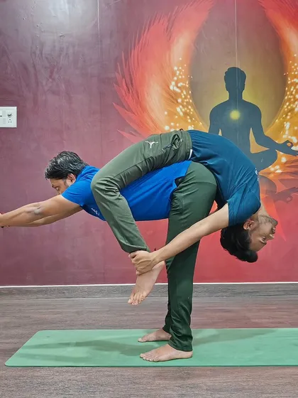 This impressive partner pose combines a standing forward bend with a backbend, requiring immense trust and mutual support.